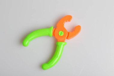 Oyuncak pense gri bir arkaplanda izole edildi