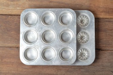 Tahta bir arka planda izole edilmiş alüminyum kurabiye şekli