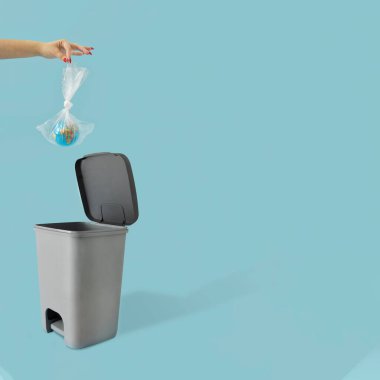 Plastik çöp torbasında Dünya gezegeninin yaratıcı ekolojik konsepti. Pastel mavi arka plan. Çevremizi kurtar, kese kağıdı kullan..