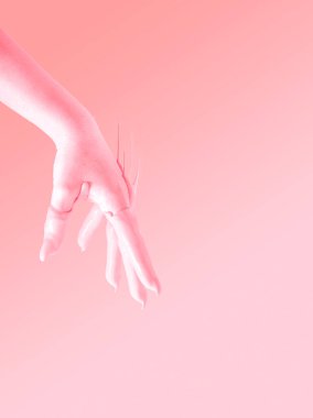Havadaki şeftali boyasına batırılmış yükseltilmiş el konsepti. Pastel pembe arkaplan.