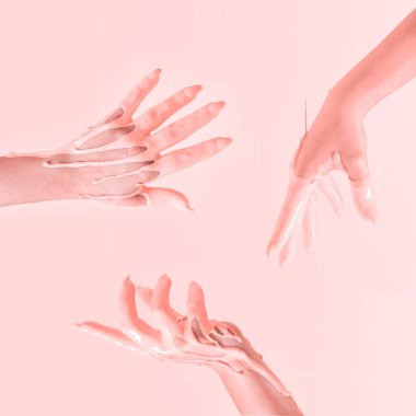 Havaya şeftali boyasına batırılmış el kaldırma fikri yaratıcıydı. Pastel pembe arkaplan.