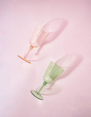 Summer beach vintage party concept of wine glasses on pastel pink background. Vacation mood on. Flat lay.