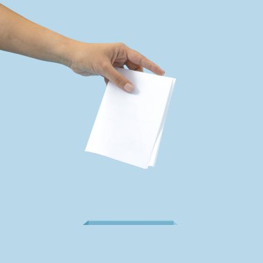 Creative concept of inserting the ballot into the box. It is your right to vote, exercise your right. Blue background.