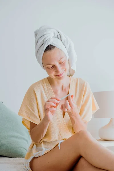 Jovem Mulher Roupão Banho Uma Toalha Cabeça Uma Manicure Usando — Fotografia de Stock