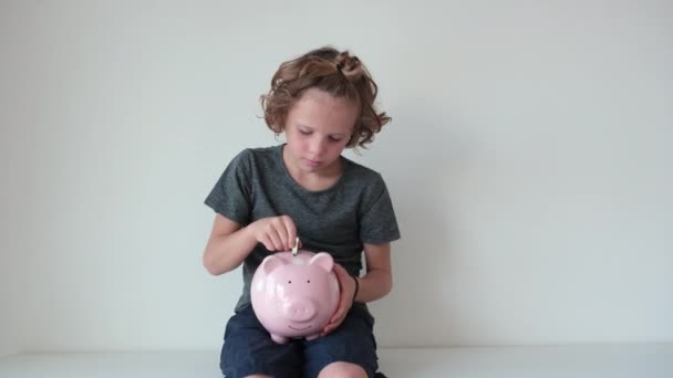 Aranyos Kisfiú Érméket Tesz Egy Malacperselybe Megtakarításként Pénzügyi Oktatás — Stock videók