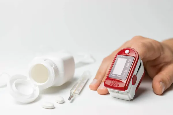 Kézzel Egy Hordozható Impulzus Oximéter Egy Ujj Hőmérő Tabletták Izolált — Stock Fotó