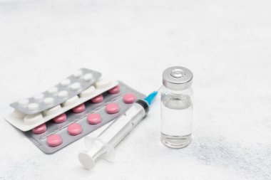 Beyaz arka planda tıbbi şırınga, ilaç hapları ve cam şişe, ilaç ve tedavi konsepti.