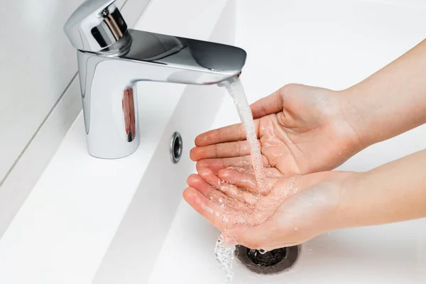 浴室の石鹸なしで蛇口から水をストリーミングの下で手を洗う若い女性 衛生コンセプト — ストック写真