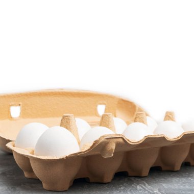 Gri desenli arka planda kutuda beyaz tavuk yumurtası..