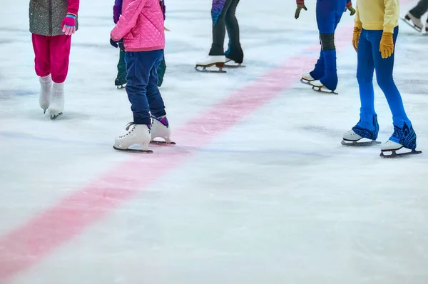 Skates on the ice of the ice arena. A group of young girls at the training session of the figure skating sports section. Selective focus. Copy space.