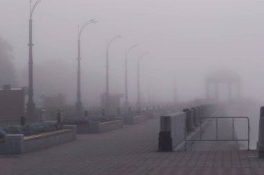 Yoğun siste bir gezinti. Yaz sabahının başında. Mevsimlik sel dönemi. Rotunda 'nın silueti ve güçlü bulanık fenerler. Blagoveshchensk, Rusya.