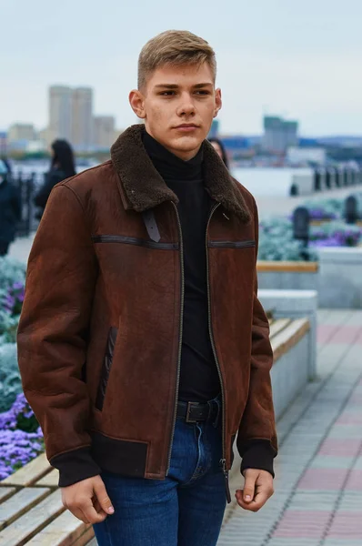 Retrato de um jovem branco loiro em uma jaqueta marrom de couro quente. Acne da pele. Fotos De Bancos De Imagens Sem Royalties