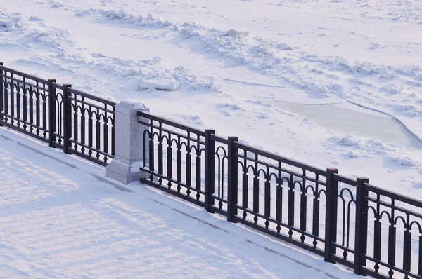 被冰覆盖的河岸人行道 覆盖着白雪的冬城堤岸 栅栏格栅的阴影 Blagoveshchensk 俄罗斯联邦 — 图库照片