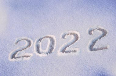 2022 beyaz kar yüzeyine el çizimi harfleri. Kış tatili teması. Yukarıdan bak. Düz yatıyordu.