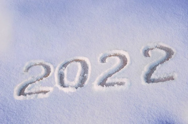 2022 beyaz kar yüzeyine el çizimi harfleri. Kış tatili teması. Yukarıdan bak. Düz yatıyordu.