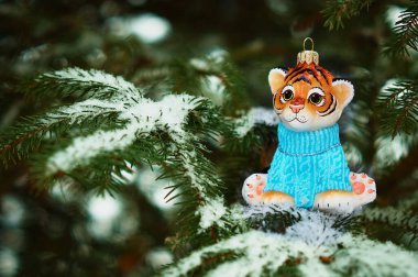 Kızıl Dicle karlı bir yılbaşı ağacının dalında. 2022 yılının kaplan sembolü. Mutlu noeller. Mutlu yıllar..