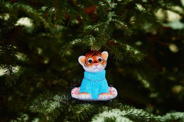 Kızıl Dicle karlı bir yılbaşı ağacının dalında. 2022 yılının kaplan sembolü. Noel ağacının üzerinde, ormanda Noel ağacı oyuncağı. Mutlu yıllar..