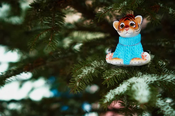 Kızıl Dicle karlı bir yılbaşı ağacının dalında. 2022 yılının kaplan sembolü. Mutlu noeller. Mutlu yıllar..