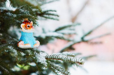 Kızıl Dicle karlı bir yılbaşı ağacının dalında. 2022 yılının kaplan sembolü. Mutlu noeller. Mutlu yıllar..