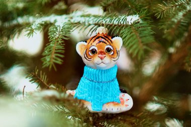 Kızıl Dicle karlı bir yılbaşı ağacının dalında. 2022 yılının kaplan sembolü. Mutlu noeller. Mutlu yıllar..