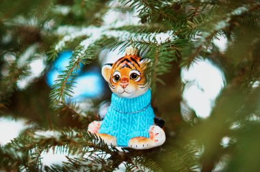 Kızıl Dicle karlı bir yılbaşı ağacının dalında. 2022 yılının kaplan sembolü. Mutlu noeller. Mutlu yıllar..