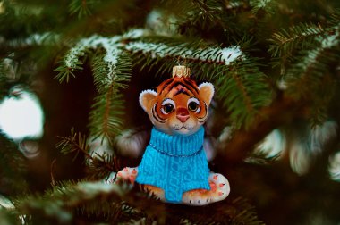 Kızıl Dicle karlı bir yılbaşı ağacının dalında. 2022 yılının kaplan sembolü. Mutlu noeller. Mutlu yıllar..