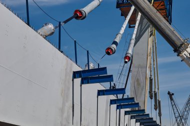 Güneşli bir havada Zeya Nehri ile birlikte inşaat sahasında bir kiriş ve bir pilon ve kablolar. Blagoveshchensk, Rusya. 2021 yıl.