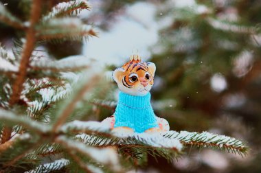 Noel ağacındaki kaplan yavrusu figürü. Çin Yeni Yılı. Kış karlı orman. Seçici odak.