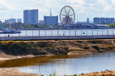 Rusya 'nın Blagoveshchensk kentinde sel baskını sırasında Amur Nehri yakınlarında bir vakıf çukuru açıldı. Teleferik terminalinin inşaatı. Gemi, dönme dolap ve Heihe City, Çin.