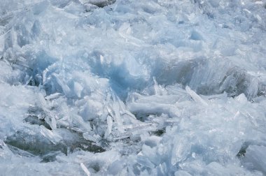 Eriyen nehir buzu. Kristallerin kolon ve iğne benzeri yapısı. İlkbaharda Amur Nehri 'nin kıyısında buz kütlesi. Yakın görüş. Büyük katı su blokları. Seçici odak.