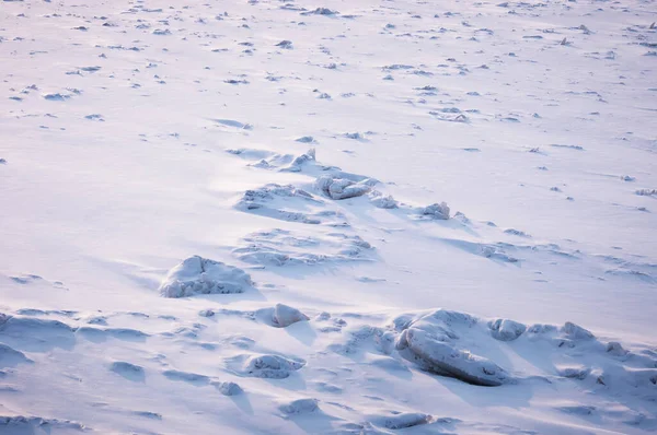 凍った川に白い雪で覆われた氷の破片。冬の背景の質感。早朝のハイライトと影。柔らかい形 — ストック写真