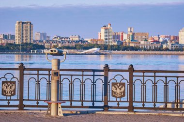 Amur Nehri 'nin seti üzerinde sabit dürbünler. Arka planda Çin 'in Heihe kenti bulanık. Rusya Federasyonu 'nun arması ile birlikte. Blagoveshchensk, Rusya.