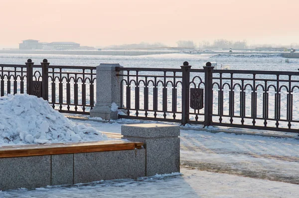 冬には花壇のあるベンチは 雪のドリフトで満たされています 街の堤防のプロムナード 二重使用の概念 背景には中国の平安市があります ロシアのBlagoveshchensk — ストック写真