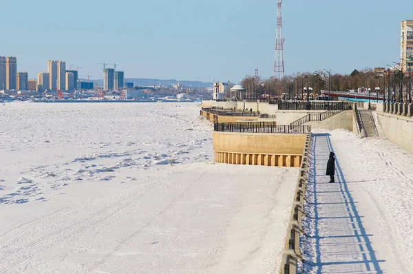 The Amur River on the border between China and Russia in winter. Border Patrol ski track on snowy ice. The city of Heihe is in the background. View from the embankment of the city of Blagoveshchensk.