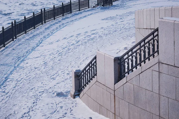 阿穆尔河白雪覆盖的城市堤岸的碎片 冬天的早晨金属和花岗岩 有栅栏的楼梯 白雪地毯上的人和动物痕迹 — 图库照片