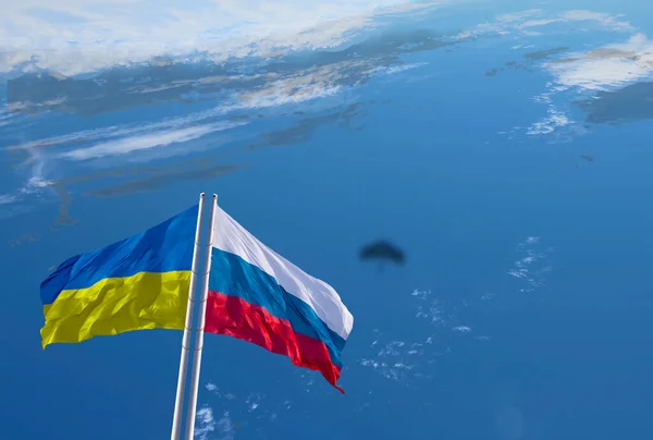 Flags of Russia and Ukraine in the form of airplane wings. Flight over the planet Earth. The concept of friendship of peoples, peace and security. Stop the escalation of the conflict. Collage.