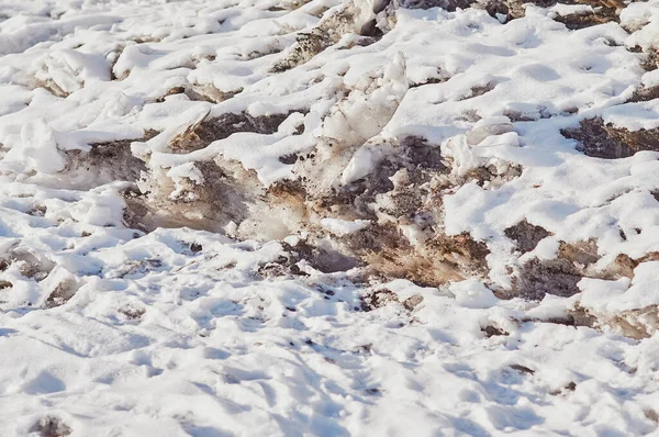 Natural texture of melting snow and ice in spring. The loose structure of snow is covered with a new fresh layer after a snowfall. Sunny day. — Stock Photo, Image