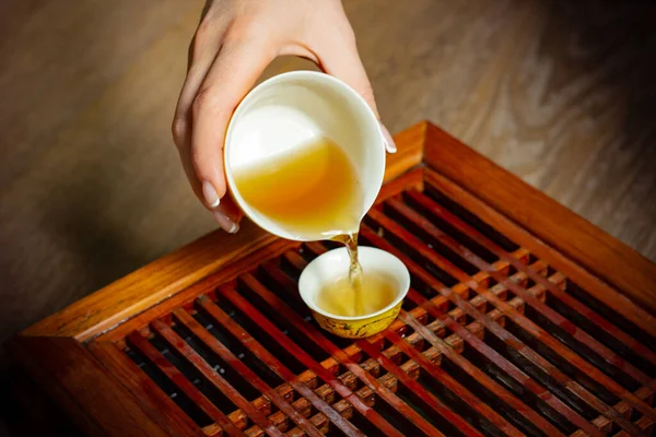 Set da tè vista dall'alto tavolo in legno per sfondo cerimonia del tè. Donna che tiene una tazza di tè — Foto Stock