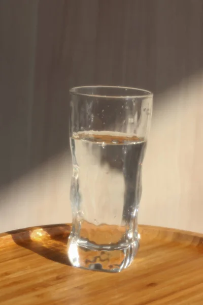 A glass of water in the morning lights and shadows — Stock Photo, Image