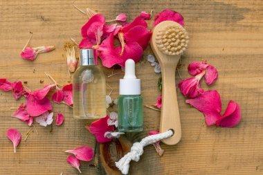 Spa doğal tedavi fikri: tahta fırça ve doğal ahşap arka planda iki güzellik ürünü şişesi. Eko doğal kozmetik için fikir