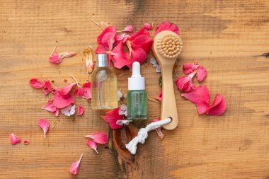 Tahta bir fırça ve doğal ahşap zemin üzerinde iki güzellik ürünü şişesinin düz kompozisyonu. Eko doğal kozmetik için fikir