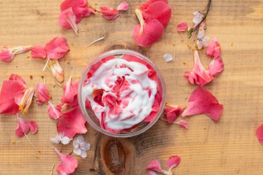 Taze koyu pembe çiçek yaprakları ve nemlendiriciyle dolu bir güzellik ürünleri kabının düz bileşimi. Doğal kozmetik ürünleri için fikir uydurma