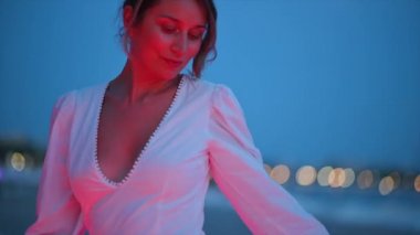 Beyaz elbiseli kadın Fransa 'nın Cannes sokağında yürüyor.