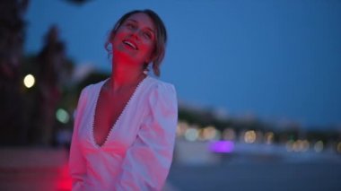 Beyaz elbiseli kadın Fransa 'nın Cannes sokağında yürüyor.