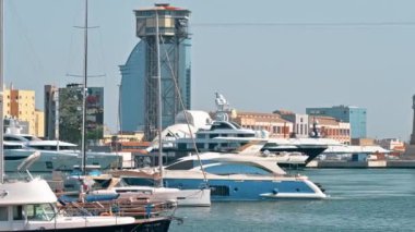 BARCELONA, İspanya - 15 Haziran 2021 Deniz Limanı. Birçok demirli yat, güneşli hava, yüzen tekne, arka planda binalar.