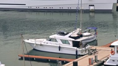 BARCELONA, İspanya - 19 Haziran 2021 Deniz Limanı. Armudun yanında demirli bir tekne ve üzerinde bir adam var.