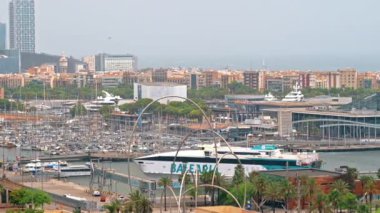 BARCELONA, İspanya - 19 Haziran 2021: Bulutlu havada deniz limanı bölgesi. Demir atan feribot, çok sayıda demirli tekne ve bina.