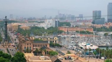 BARCELONA, İspanya - 19 Haziran 2021: Bulutlu havada deniz limanı bölgesi. Columbus anıtı, eski hükümet binası, arabalı yol, çoklu demirli kayıklar, binalar.