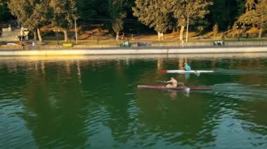 CHISINAU, MOLDOVA - 4 Eylül 2021: günbatımında Valea Morilor parkının hava aracı görüntüsü. Yeşillik, göl, iki adam kayak yapıyor.