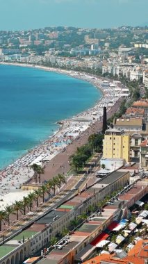 Nice, Fransa 'daki Cote d' Azur manzarası. Sahilde dinlenen insanlar, binalar, Akdeniz 'in mavi suları.